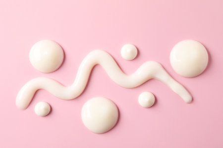 Cream on pink background, flat lay. Samples of cosmetic productの写真素材