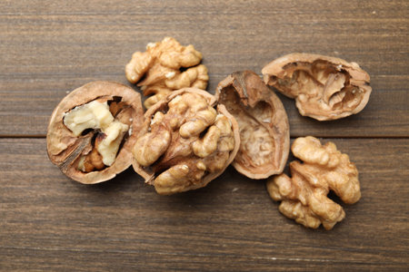 Fresh walnuts with shells on wooden table, flat layの写真素材
