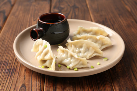 Tasty gyoza (dumplings) and soy sauce on wooden table, closeupの写真素材
