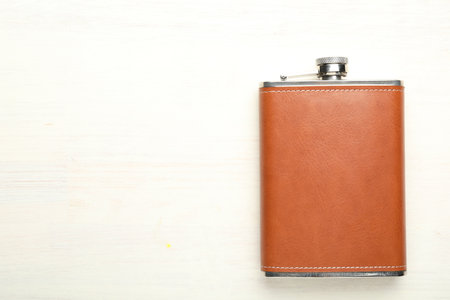 One hip flask on light wooden table, top view. Space for textの写真素材