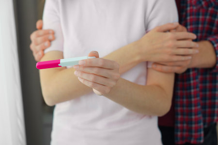 Woman with negative pregnancy test indoors, closeup. Man supporting his wife at homeの写真素材