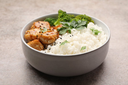 Tasty rice with broccoli, chicken and parsley on grey table, closeupの写真素材