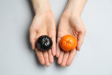 Woman with tangerines of different colors on light grey background, top viewの写真素材