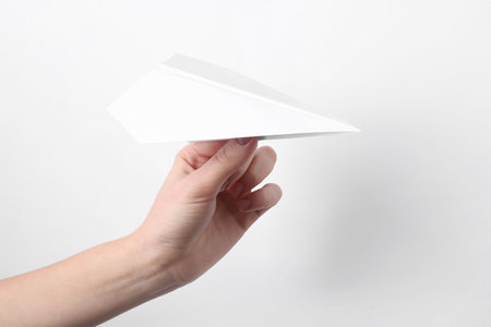 Woman with handmade paper plane on white background, closeupの写真素材