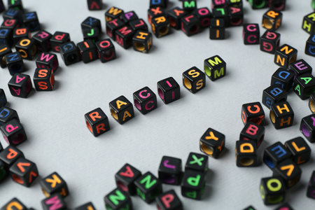 Word Racism and beads on light grey background, closeupの写真素材