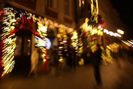 Defocused view of building with festive lights, motion blur and bokeh effect