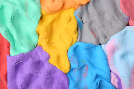 Different colorful play dough as background, top view