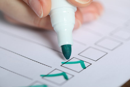 Woman checking box of paper form at table, closeup