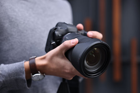 Professional photographer with modern camera outdoors, closeup