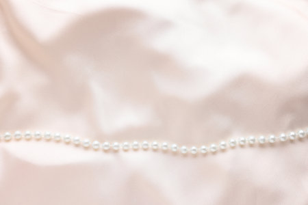 Beautiful pearl necklace on beige cloth, top view. Space for textの写真素材
