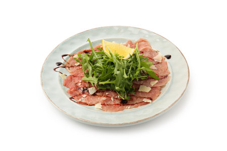 Delicious beef carpaccio with arugula, cheese, balsamic vinegar and lemon isolated on whiteの写真素材