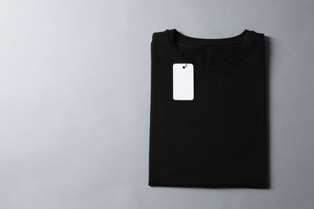 Blank black t-shirt on grey background, top view. Mockup for designの写真素材