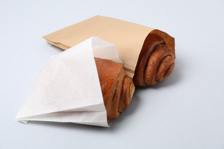 Paper bags with freshly baked buns on white background, closeupの写真素材