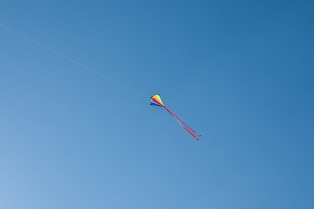 One colorful kite flying in blue skyの写真素材