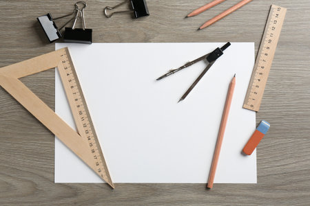 Flat lay composition with ruler and other stationery on wooden table, space for text