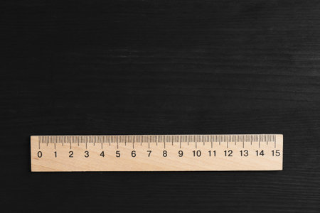 One ruler on black wooden table, top view. Space for textの写真素材