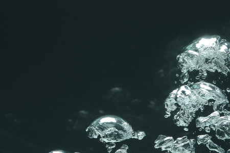Many water bubbles on dark background, closeup. Space for text
