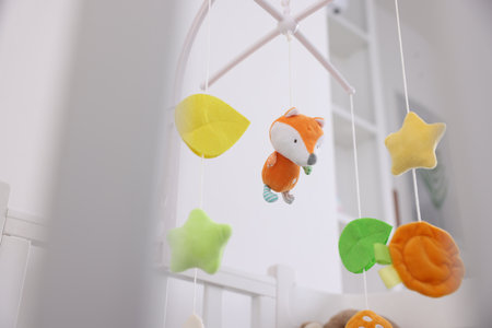 Crib with cute baby mobile in room, low angle viewの写真素材