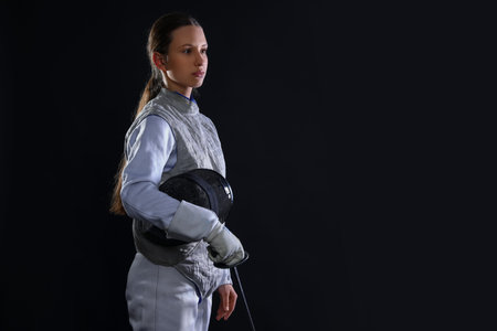 Fencer with epee on black background, space for text