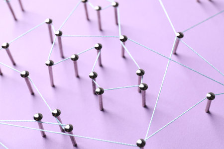 Network connection. Nails linked together by thread on violet background, closeupの写真素材