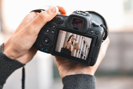 Professional photographer with modern camera outdoors, closeup