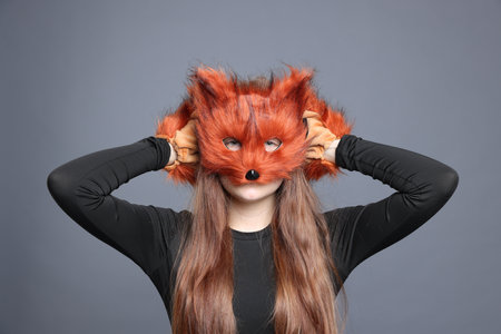 Quadrobics. Girl wearing fox mask and gloves on grey backgroundの写真素材