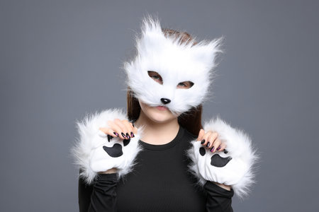 Quadrobics. Girl wearing cat mask and gloves on grey backgroundの写真素材