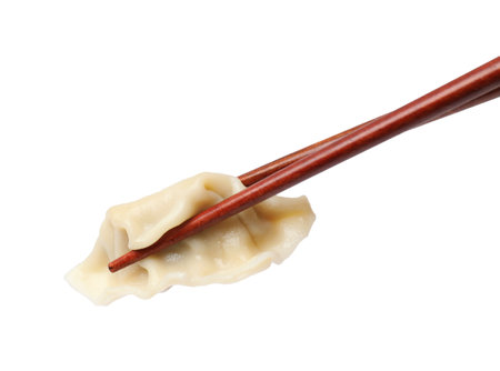 Chopsticks with fresh gyoza dumpling isolated on whiteの写真素材