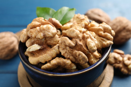 Fresh walnuts in bowl on blue table, closeupの写真素材