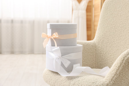 Gift boxes for wedding day in armchair indoors, space for text