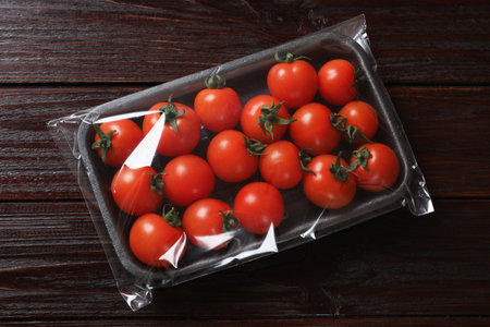 Pack of fresh tomatoes on wooden table, top viewの写真素材