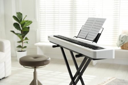 Synthesizer with music sheets and stool at home