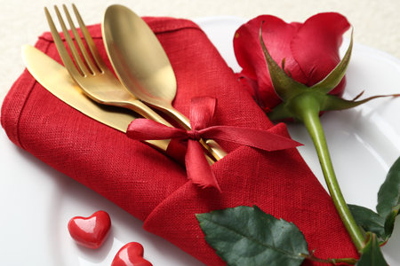 Romantic place setting with red rose on white table, closeup. Valentine's day celebrationの写真素材