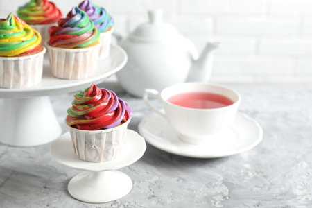 Delicious cupcake with colorful cream on gray textured table, closeupの写真素材