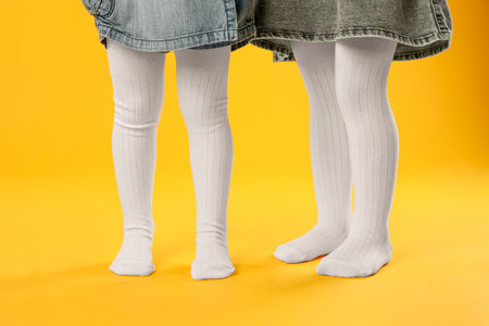 Kids wearing tights on orange background, closeupの写真素材