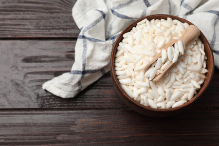 Puffed rice in bowl and scoop on wooden table, top viewの写真素材