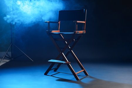 One empty director's chair on dark blue background with smokeの写真素材