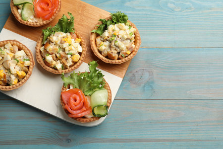 Tartlets with delicious fillings on blue wooden table, top view. Space for textの写真素材