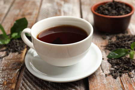 Aromatic tea, brew and fresh leaves on wooden table, closeupの写真素材
