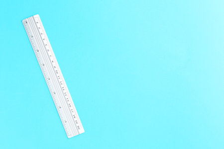One metal ruler on light blue background, top view. Space for text