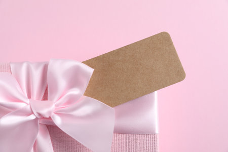 Gift box with blank tag on light pink background, closeupの写真素材