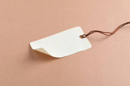 Blank tag with string on beige background, closeupの写真素材