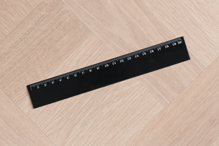 One black ruler on wooden table, top view