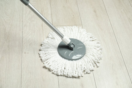 String mop on wooden floor. Cleaning equipmentの写真素材