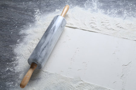 Rolling pin and flour on gray textured table, closeupの写真素材