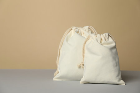 Cotton bags on gray table against beige background, space for textの写真素材