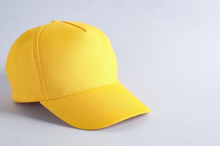 Stylish yellow baseball cap on light gray background, closeup. Mockup for design