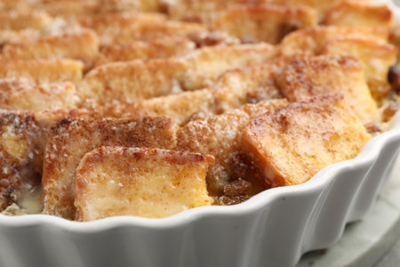 Delicious bread pudding with raisins and cinnamon in dish, closeupの写真素材
