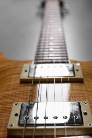 Modern electric guitar on grey background, closeup
