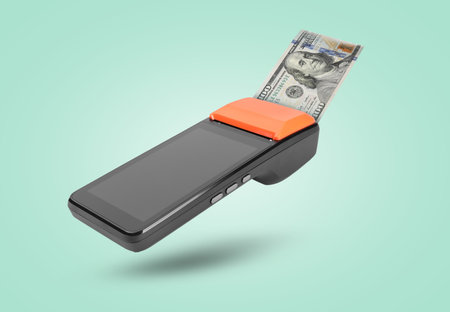 Payment terminal with dollar in air on turquoise backgroundの写真素材